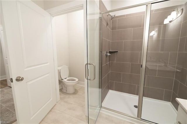 bathroom featuring vanity, an enclosed shower, tile patterned flooring, and toilet