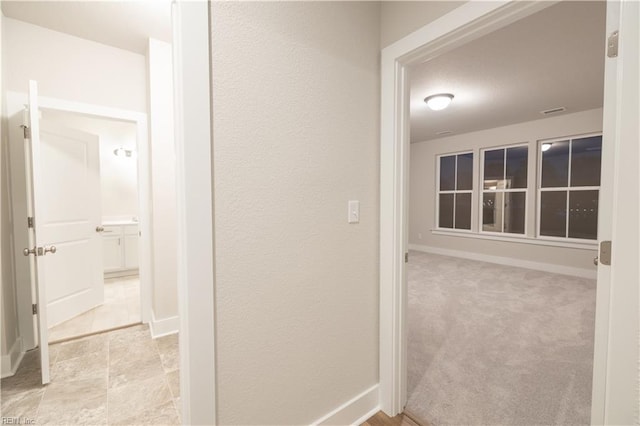 hallway with light colored carpet