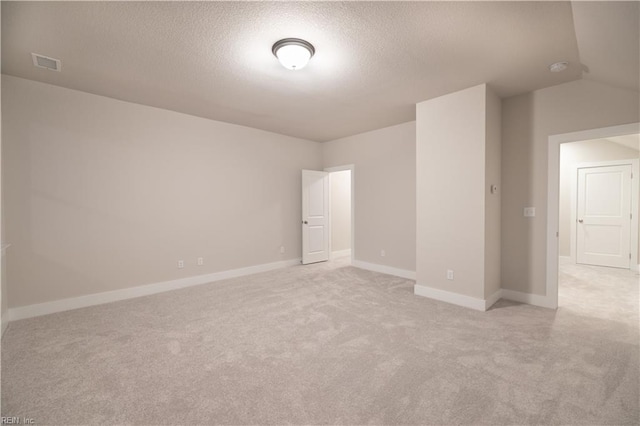 spare room with light carpet and a textured ceiling