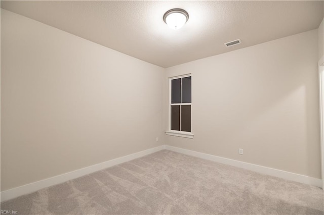 carpeted spare room with a textured ceiling