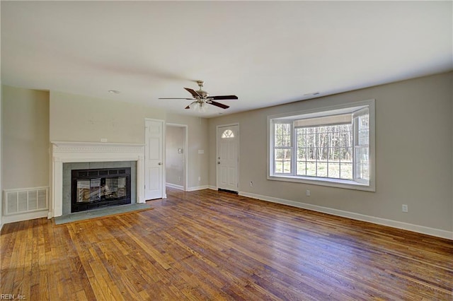 unfurnished living room featuring a fireplace, hardwood / wood-style flooring, and ceiling fan