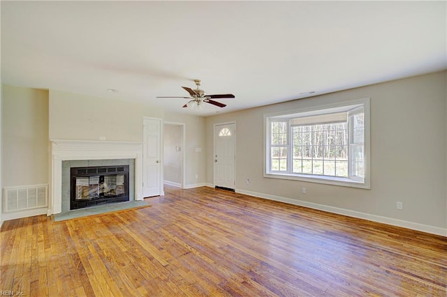 unfurnished living room with a fireplace, hardwood / wood-style floors, and ceiling fan