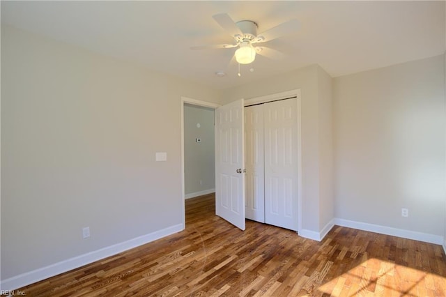 unfurnished bedroom with hardwood / wood-style flooring, ceiling fan, and a closet