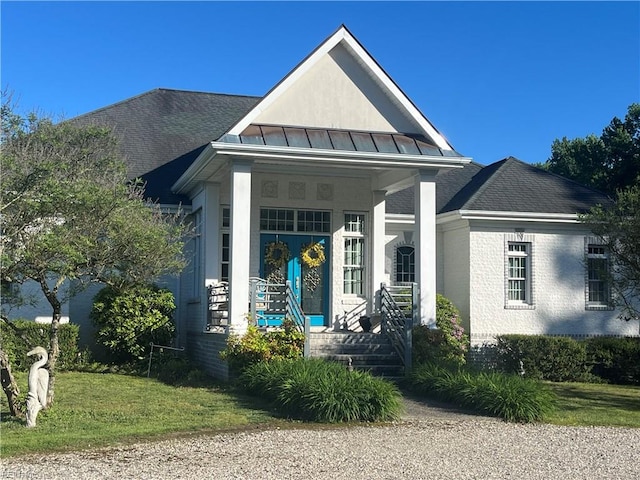 view of front facade with a front lawn and covered porch