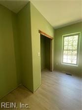 unfurnished bedroom featuring light wood-type flooring and a closet