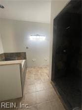 bathroom with tile patterned floors and a shower