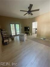 unfurnished living room with ceiling fan and wood-type flooring