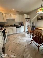 kitchen featuring white cabinets, light tile patterned floors, and white appliances