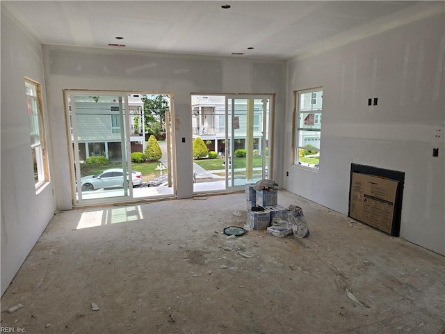 unfurnished living room with a fireplace and a wealth of natural light