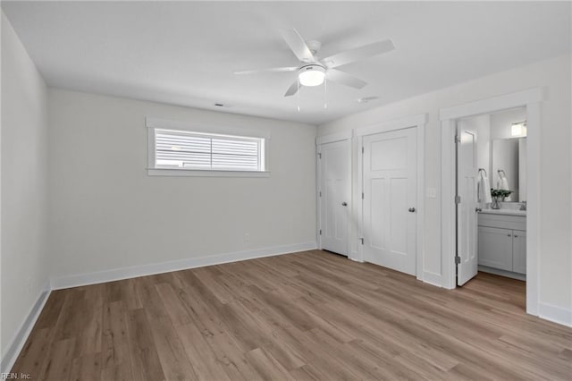 unfurnished bedroom featuring ceiling fan, light wood-type flooring, and connected bathroom