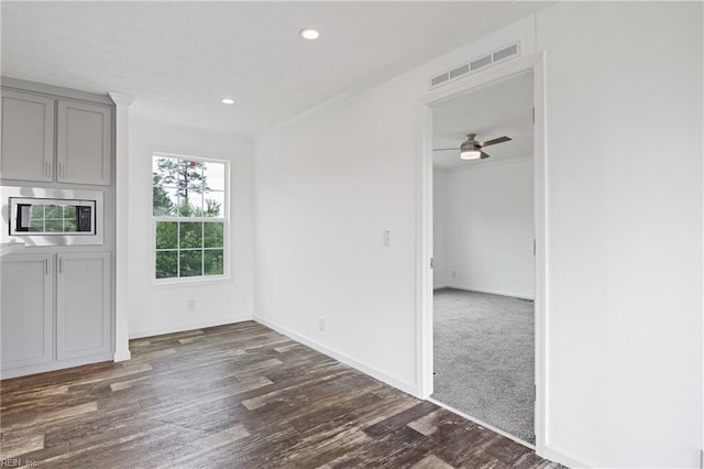 unfurnished dining area with dark hardwood / wood-style floors and ceiling fan