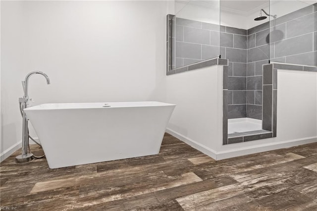 bathroom with a tile shower and wood-type flooring