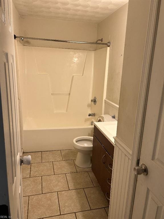 full bathroom with a textured ceiling, tile floors, tub / shower combination, vanity, and toilet