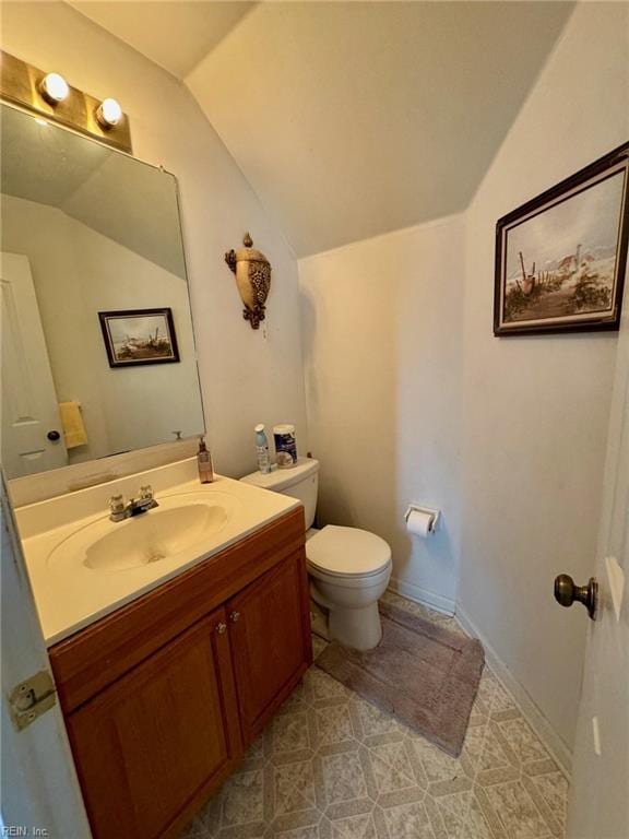 bathroom featuring vanity, vaulted ceiling, and toilet