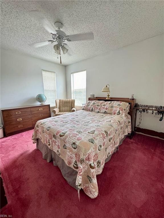 bedroom with dark colored carpet, a textured ceiling, and ceiling fan