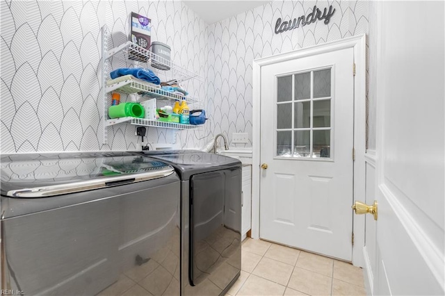 laundry room featuring light tile patterned floors, independent washer and dryer, and sink