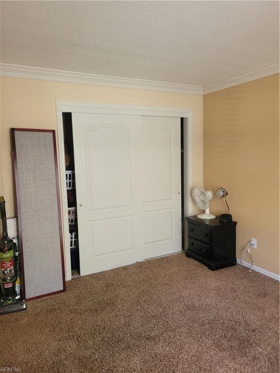 bedroom with a textured ceiling, ornamental molding, carpet floors, and a closet