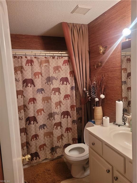 bathroom featuring vanity, toilet, and a textured ceiling