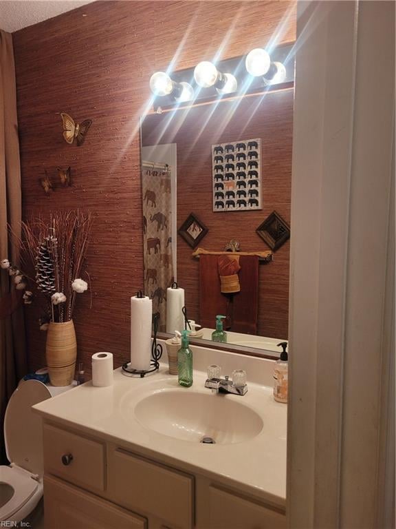 bathroom featuring toilet and vanity with extensive cabinet space