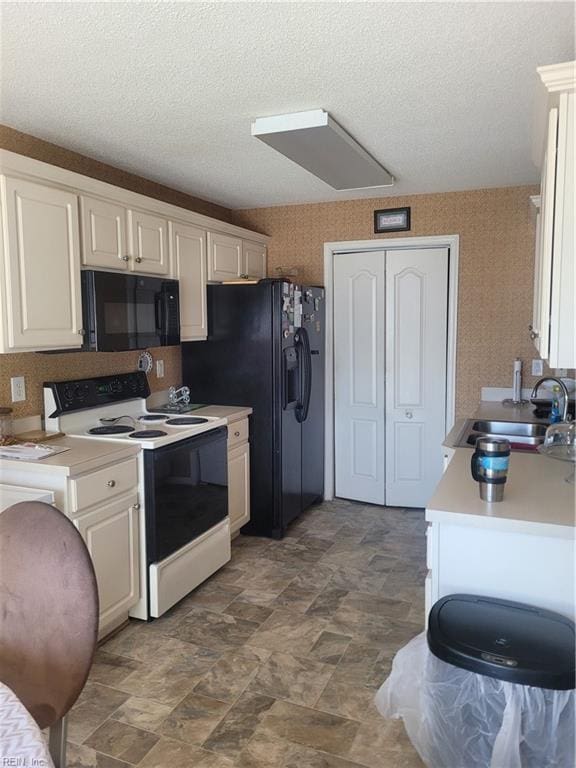 kitchen with white cabinets, sink, black appliances, and dark tile floors