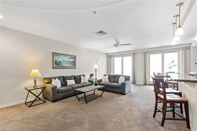 carpeted living room with ceiling fan