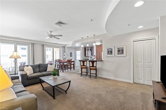 living room featuring a wealth of natural light, light colored carpet, and ceiling fan