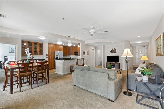 carpeted living room with ceiling fan