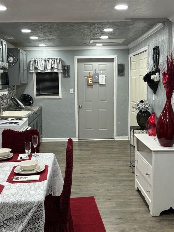 dining room featuring dark wood-type flooring, ornamental molding, and sink