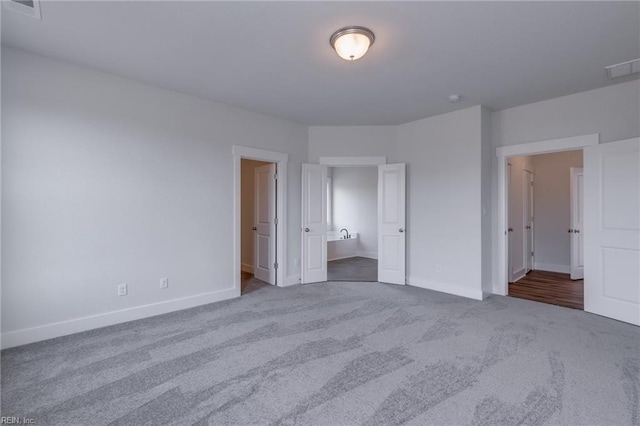 unfurnished bedroom featuring carpet and ensuite bathroom