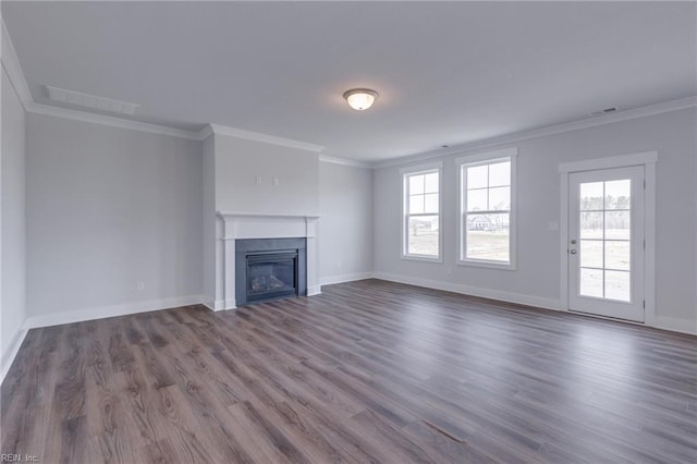 unfurnished living room featuring a healthy amount of sunlight, crown molding, and wood-type flooring