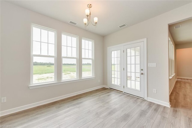 interior space featuring a chandelier and light hardwood / wood-style flooring