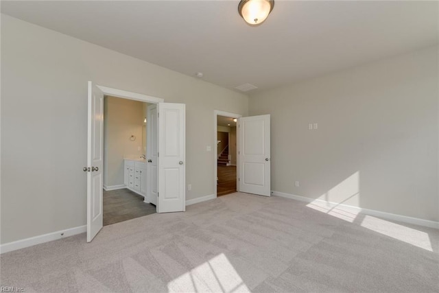 unfurnished bedroom featuring carpet flooring and ensuite bathroom