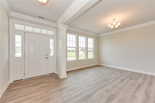 foyer featuring crown molding, ornate columns, a chandelier, and light hardwood / wood-style flooring