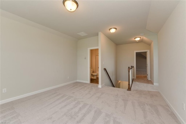 carpeted spare room with lofted ceiling