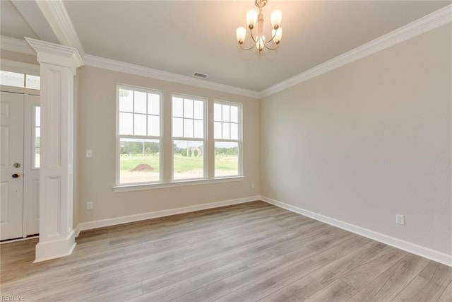 interior space with ornate columns, a chandelier, light hardwood / wood-style flooring, and ornamental molding