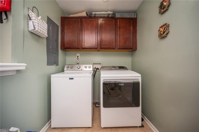 washroom featuring washing machine and dryer, electric panel, light tile patterned flooring, and cabinets