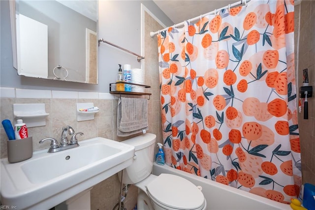 full bathroom with sink, shower / bath combo, toilet, and tile walls