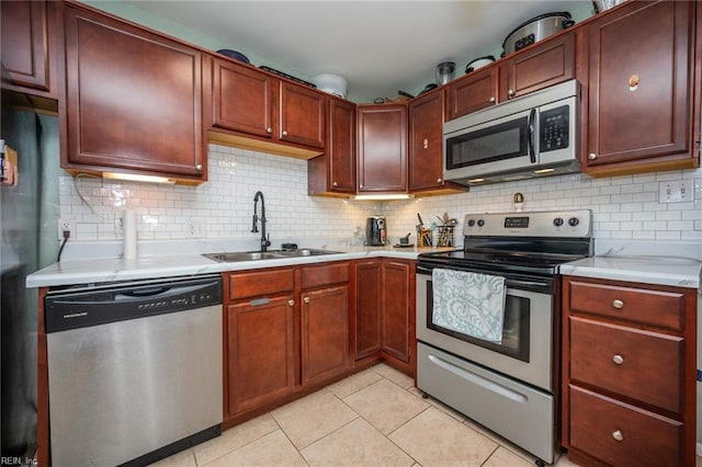 kitchen with backsplash, light tile patterned flooring, sink, and stainless steel appliances