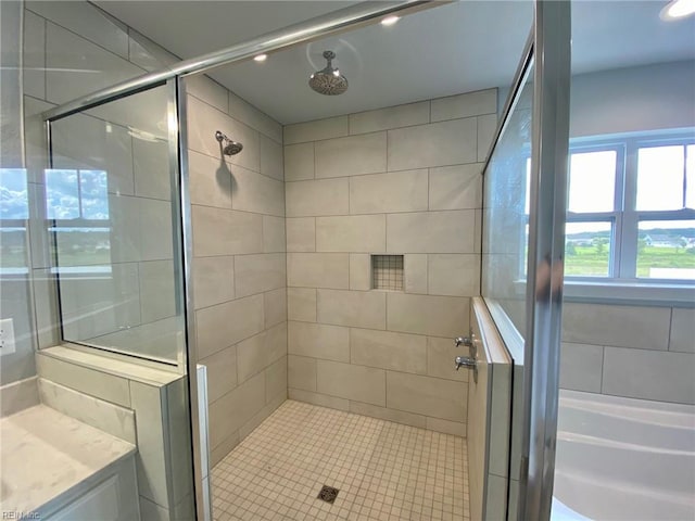 bathroom featuring a shower with shower door and vanity