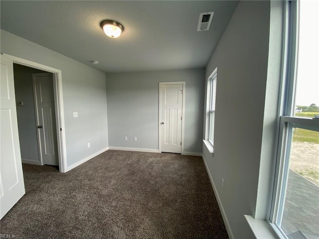 carpeted empty room featuring plenty of natural light