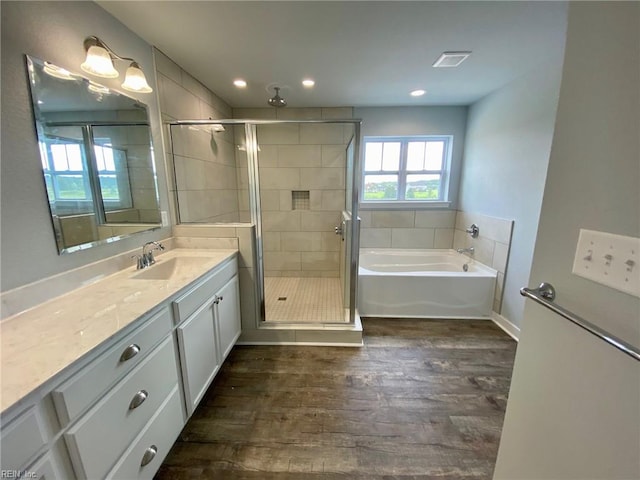 bathroom with hardwood / wood-style flooring, vanity, and separate shower and tub