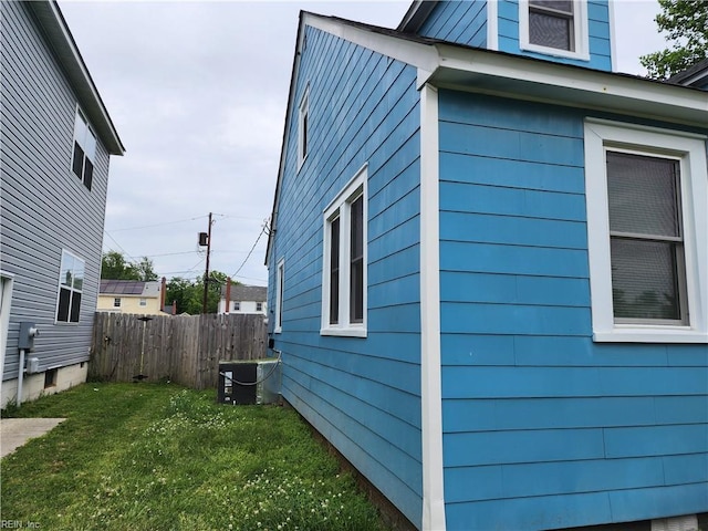 view of home's exterior with a lawn and central AC unit