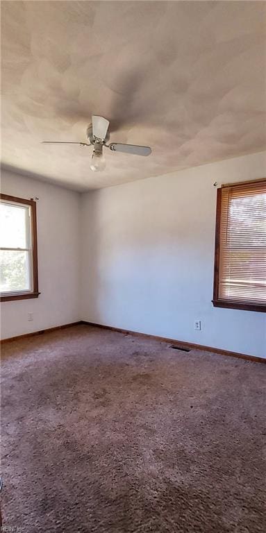 carpeted spare room with ceiling fan