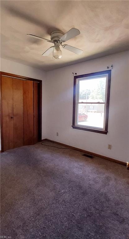 unfurnished bedroom with a closet, carpet, and ceiling fan