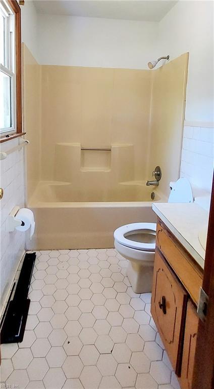 full bathroom featuring tile floors, bathtub / shower combination, vanity, and toilet