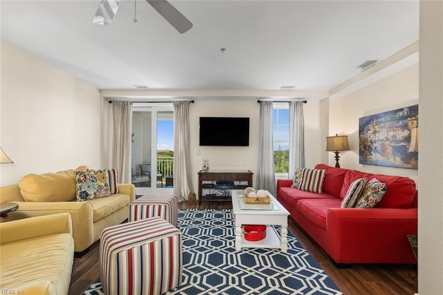 living room featuring ceiling fan and dark wood-type flooring