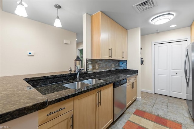 kitchen featuring light brown cabinets, stainless steel appliances, hanging light fixtures, and sink