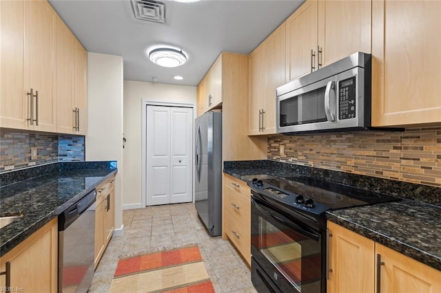 kitchen featuring light brown cabinets, dark stone countertops, backsplash, and appliances with stainless steel finishes