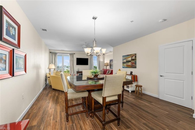 dining area featuring dark hardwood / wood-style floors and a notable chandelier