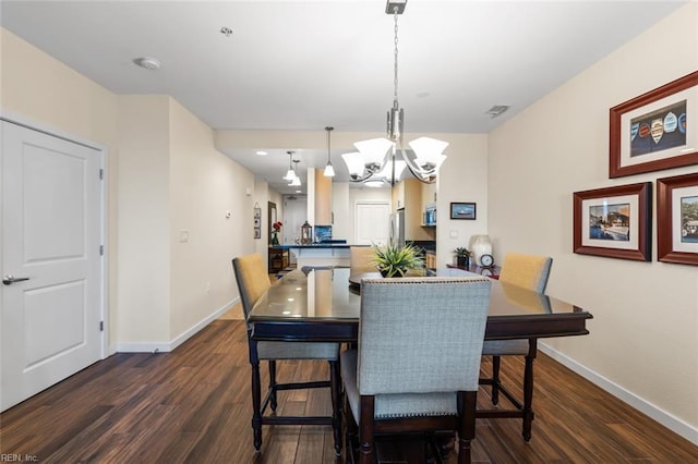 dining space with dark hardwood / wood-style flooring and a notable chandelier